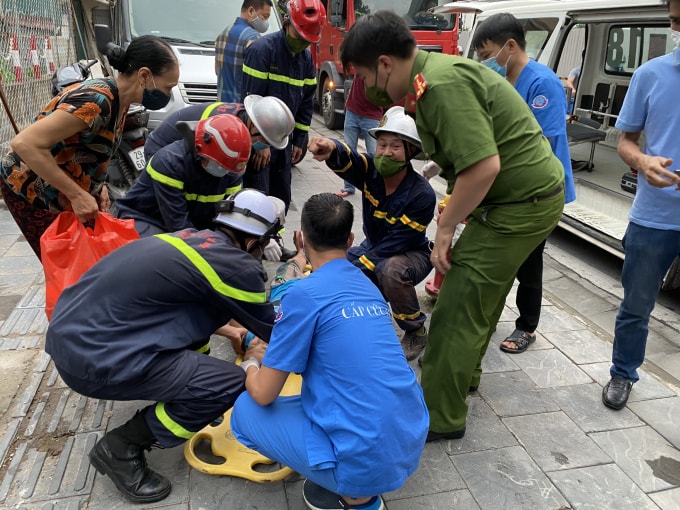Lực lượng chức năng và người dân nhanh chóng đưa cháu đến bệnh viện sau khi đã cứu ra ngoài.