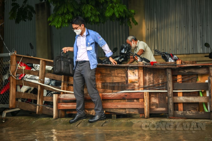 Người đi bộ di chuyển khó khăn, khi trước mặt đường đã ngập nước.