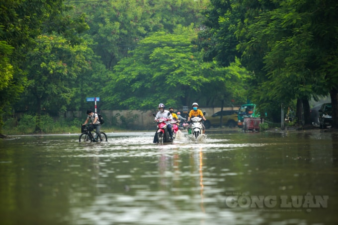 Nhiều người đi xe đạp đã phải rẽ lên vỉa hè chờ nước rút, vì nước quá cao không thể đi nổi.