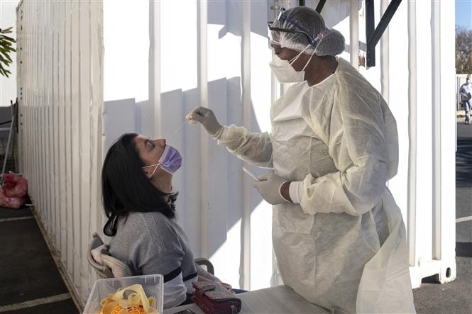 Nhân viên y tế lấy mẫu xét nghiệm COVID-19 cho người dân tại Johannesburg, Nam Phi, ngày 28/6/2021. Ảnh: AFP