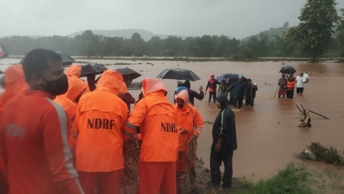 Các lực lượng cứu hộ sơ tán người dân khỏi vùng lũ - Ảnh: AFP