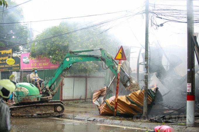 Khoảng 14h30', lực lượng chức năng phải điều 1 chiếc máy cẩu đến để phá tôn bên ngoài, giúp cho việc dập lửa được nhanh chóng.