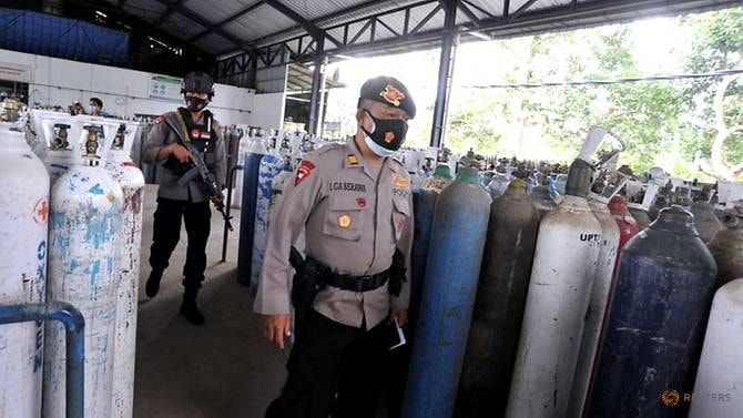 Lực lượng cảnh sát bảo vệ việc phân phối oxy tại một nhà máy nạp khí trong bối cảnh dịch bệnh COVID-19 bùng phát ở Mengwi, Badung, Bali, Indonesia, ngày 22 tháng 7 năm 2021 - Ảnh: Reuters