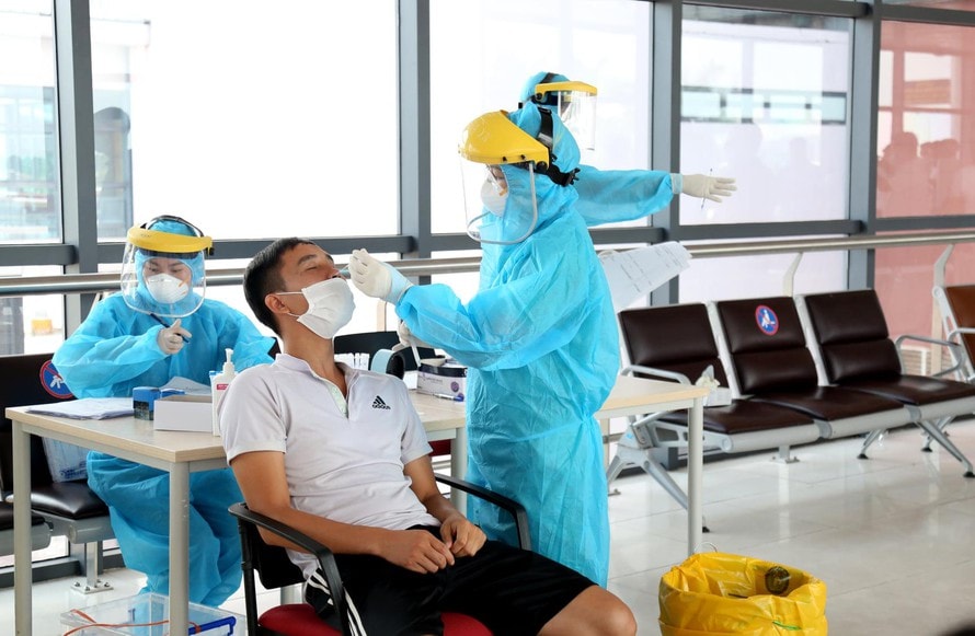 Nhân viên y tế lấy mẫu xét nghiệm Covid-19 cho người dân. Ảnh: tienphong.vn