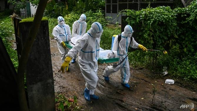 Các tình nguyện viên khiêng xác một nạn nhân COVID-19 đến nghĩa trang ở Yangon - Ảnh: AFP / Ye Aung THU