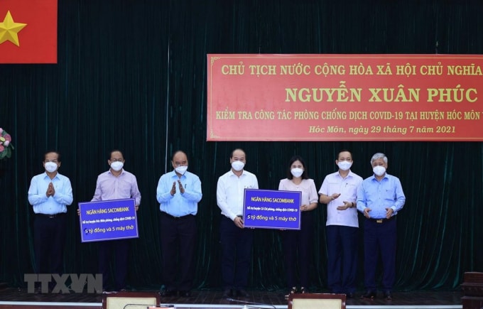 Chủ tịch nước Nguyễn Xuân Phúc chứng kiến các doanh nghiệp trao hỗ trợ công tác phòng, chống dịch Covid-19 cho huyện Hóc Môn và huyện Củ Chi. Ảnh: TTXVX