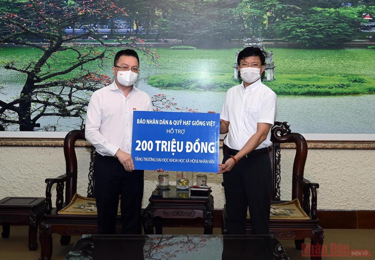 Tổng Biên tập Báo Nhân Dân Lê Quốc Minh trao quà hỗ trợ Trường đại học Khoa học Xã hội và Nhân văn. Ảnh: Duy Linh