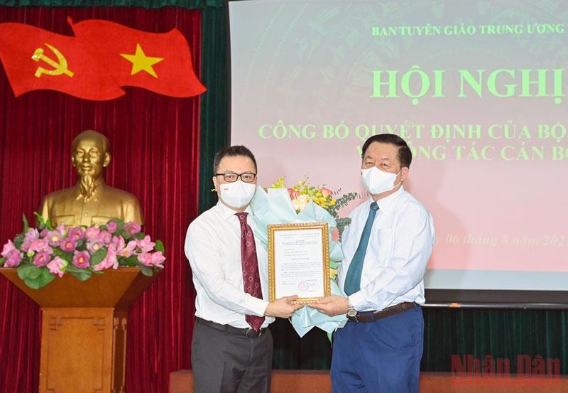 Ông Nguyễn Trọng Nghĩa, Bí thư Trung ương Đảng, Trưởng Ban Tuyên giáo Trung ương trao quyết định và tặng hoa, chúc mừng ông Lê Quốc Minh. (Ảnh: Duy Linh)