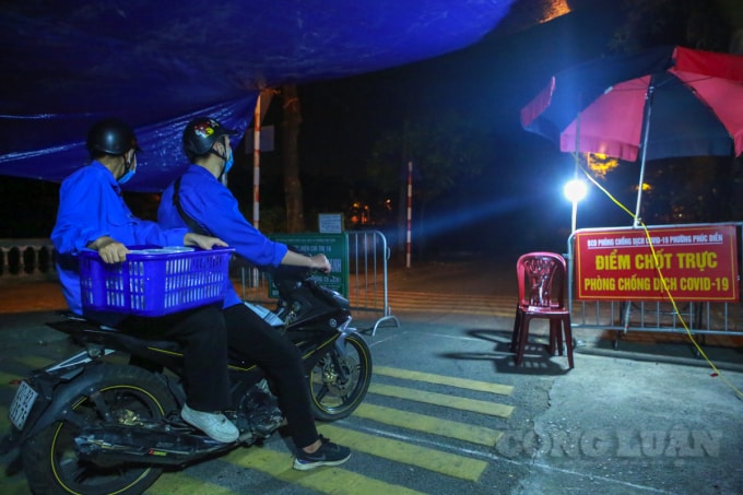 Mọi người vận chuyển cháo bằng xe máy đến các điểm chốt trực ở xa.