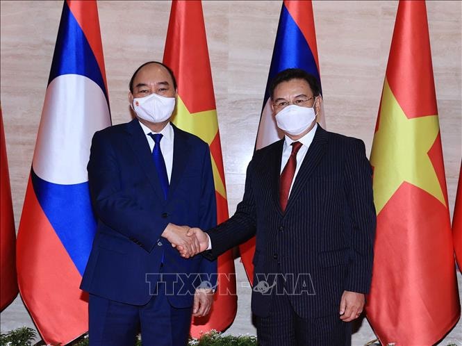 Chủ tịch nước Nguyễn Xuân Phúc bắt tay Chủ tịch Quốc hội Lào Saysomphone Phomvihane. (Ảnh: TTXVN)