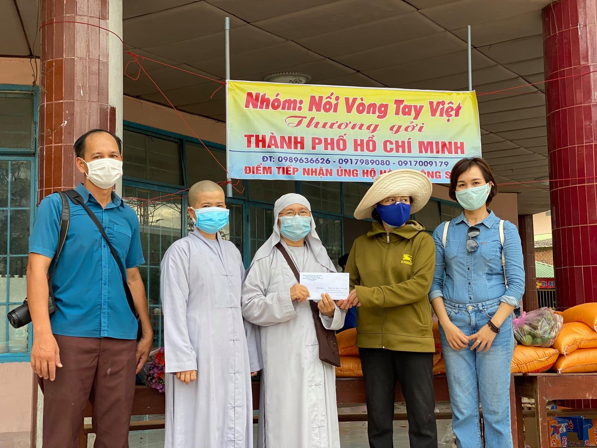 Nhà báo Lê Văn Chương- báo Biên Phòng (ngoài cùng bên trái) nhận đồ hỗ trợ của các nhà hảo tâm. Ảnh: NVCC