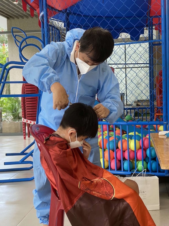 Chủ tịch Hội Nhà báo TP. Hồ Chí Minh Trần Trọng Dũng đang cắt tóc miễn phí cho cư dân trong khu chung cư nhà ông.
