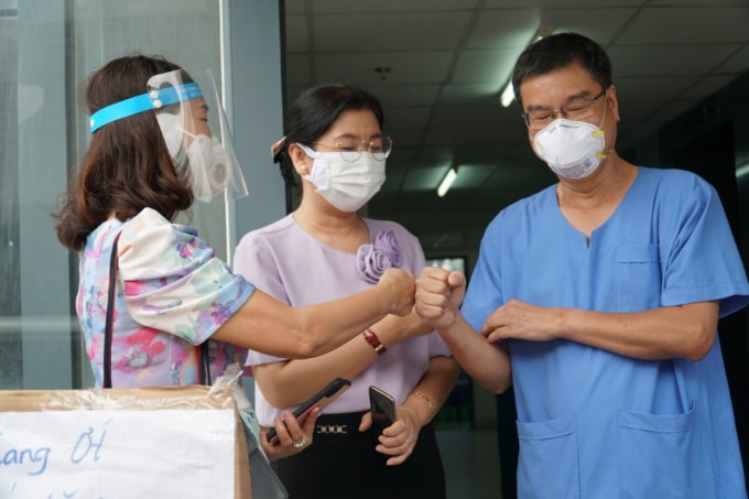 Nhà báo Lý Việt Trung (giữa) và bác sĩ Nguyễn Thanh Vĩnh- Giám đốc Bệnh viện Dã chiến số 10 trong buổi trao quà tặng các y bác sĩ. Ảnh: Tam Nguyên
