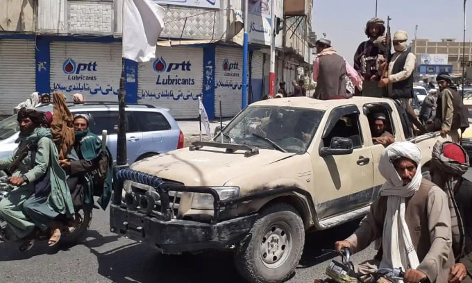 Các chiến binh Taliban lái một chiếc xe của quân đội quốc gia Afghanistan qua một con phố ở Kandahar hôm thứ Sáu. Ảnh: AFP / Getty Images