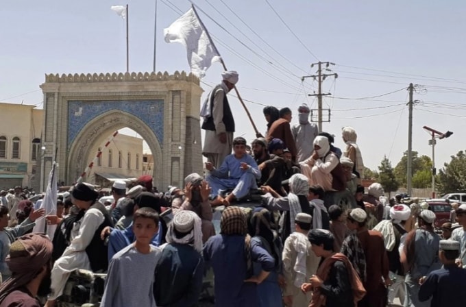 Các chiến binh Taliban đứng trên một chiếc xe dọc theo vệ đường ở Kandahar, Afghanistan. Đến nay Taliban đã chiếm 18 thành phố kể từ ngày 6/8 - Ảnh: AFP