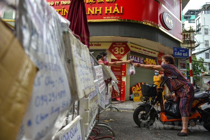 Người dân nhận hàng hóa thiết yếu đảm bảo giãn cách.
