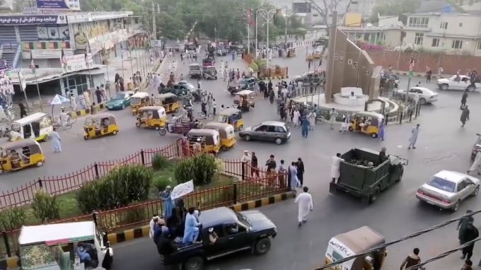 Các chiến binh Taliban vẫy cờ Taliban trên một chiếc xe bán tải chạy qua một con phố đông đúc tại khu vực Quảng trường Pashtunistan ở Jalalabad - Ảnh: Reuters