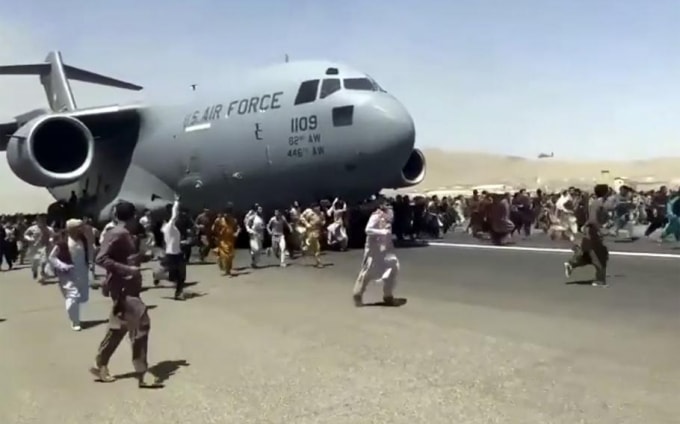 Hình ảnh hỗn loạn tại sân bay Kabul khi hàng trăm người cố gắng đu bám lên một máy bay quân sự Mỹ, với hy vọng rời khỏi Afghanistan - Ảnh: Cắt từ video