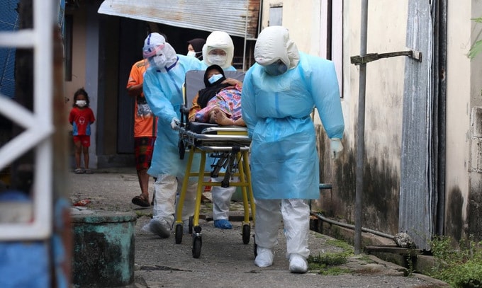Nhân viên y tế chuyển bệnh nhân nhiễm COVID-19 tới bệnh viện ở Pattani, Thái Lan. Ảnh: AFP