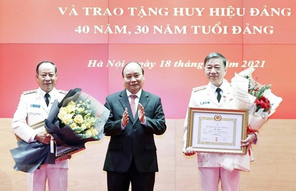 Chủ tịch nước Nguyễn Xuân Phúc trao tặng huy hiệu 40 năm tuổi Đảng cho Đại tướng Tô Lâm, Bộ trưởng Bộ Công an và Thượng tướng Lê Quý Vương, nguyên Thứ trưởng Bộ Công an. Ảnh: TTXVN