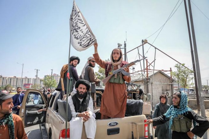 Các chiến binh Taliban giơ cờ Taliban khi tuần tra Kabul, Afghanistan, vào ngày 16 tháng 8 năm 2021 - Ảnh: Stringer / EPA-EFE