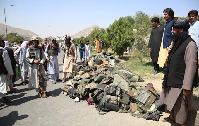 Các chiến binh Taliban thu gom đồ đạc của các binh sĩ an ninh Afghanistan đầu hàng ở Kabul, thủ đô của Afghanistan, vào ngày 16 tháng 8 năm 2021 - Ảnh: Xinhua / ZUMA Press