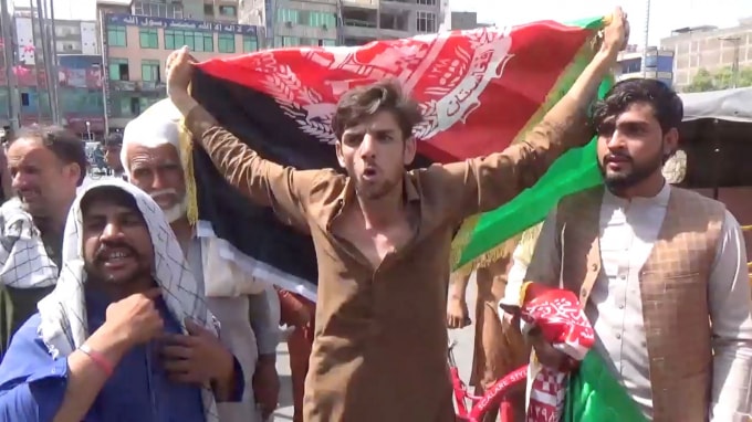 Người dân mang theo cờ Afghanistan khi họ tham gia một cuộc biểu tình chống Taliban ở Jalalabad, Afghanistan ngày 18 tháng 8 năm 2021 - Ảnh: Reuters