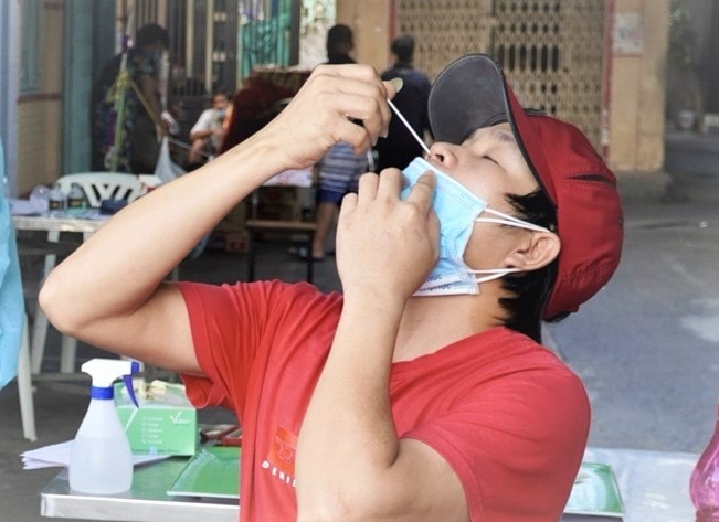 Người dân tự lấy mẫu test Covid-19 cho mình sau khi được nhân viên y tế hướng dẫn.