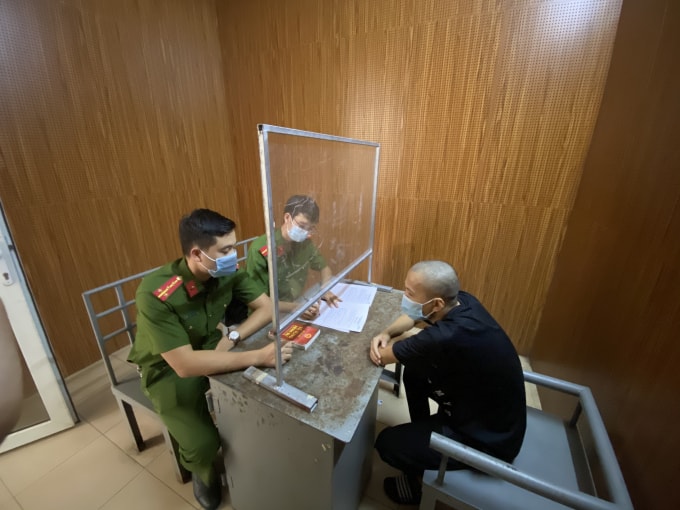Công an huyện Đan Phượng thẩm vấn đối tượng dùng điếu cày tấn công lực lượng chức năng. Ảnh: CAHN