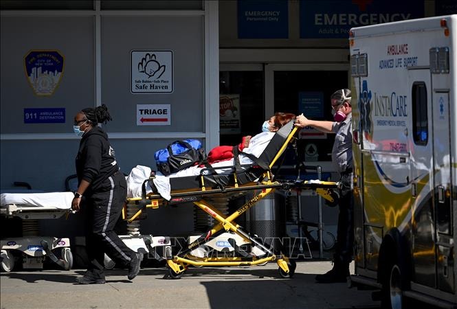 Nhân viên y tế chuyển bệnh nhân COVID-19 tới trung tâm y tế tại New York, Mỹ. Ảnh: AFP
