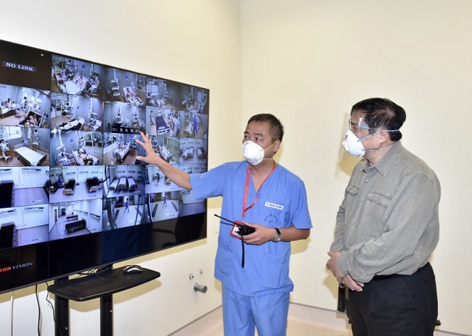 Bác sĩ Nguyễn Lân Hiếu, Giám đốc Bệnh viện Đại học Y Hà Nội phụ trách Bệnh viện dã chiến điều trị COVID-19 tại Bệnh viện quốc tế Becamex giới thiệu với Thủ tướng hoạt động điều trị chung của Bệnh viện dã chiến qua hệ thống giám sát trung tâm. Ảnh: Nhật Bắc