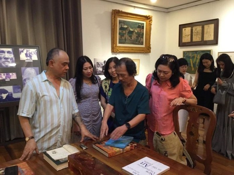 Họa sĩ Bùi Thanh Phương (áo xanh), con trai họa sĩ Bùi Xuân Phái trao một số kỷ vật của cố họa sĩ cho nhà sưu tập Trần Hậu Tuấn