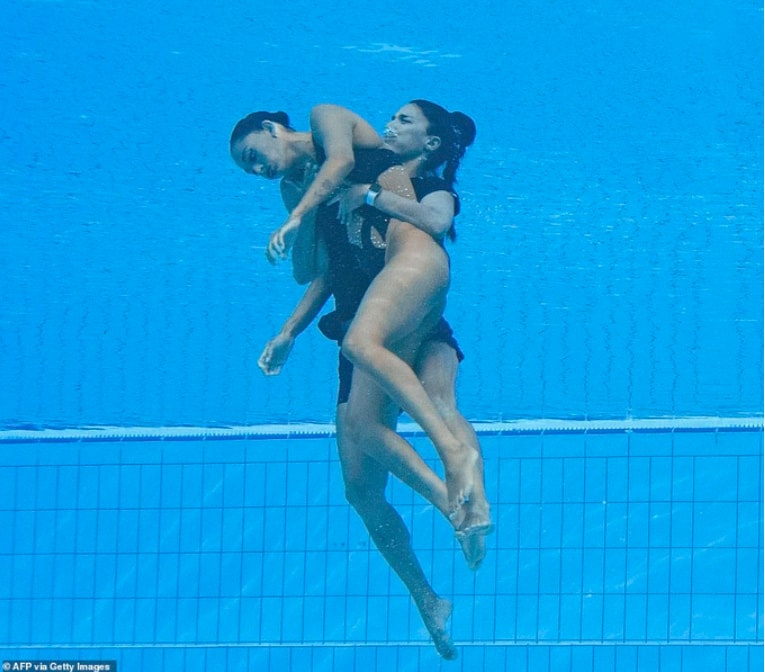 Hình ảnh HLV trưởng đội bơi Mỹ Andrea Fuentes đưa Anita lên bờ. Ảnh: AFP