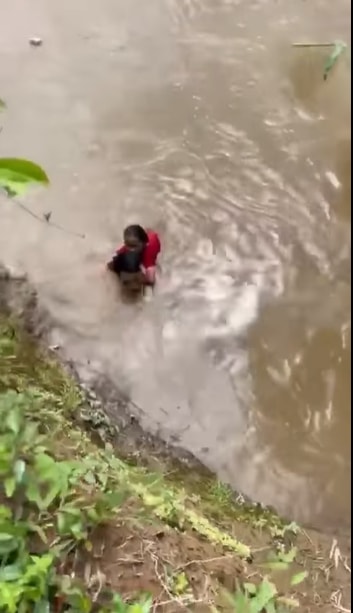 Anh Chu Quang Sao cẩn thận đưa cháu bé vào bờ an toàn. Ảnh cắt từ clip