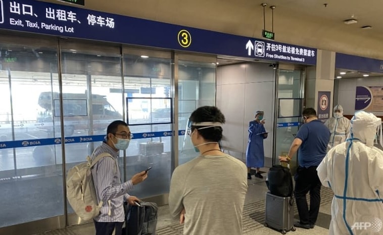Một số hành khách đang tiến hành thủ tục nhập cảnh và cách ly tại Sân bay Quốc tế Bắc Kinh, Trung Quốc. Ảnh: AFP
