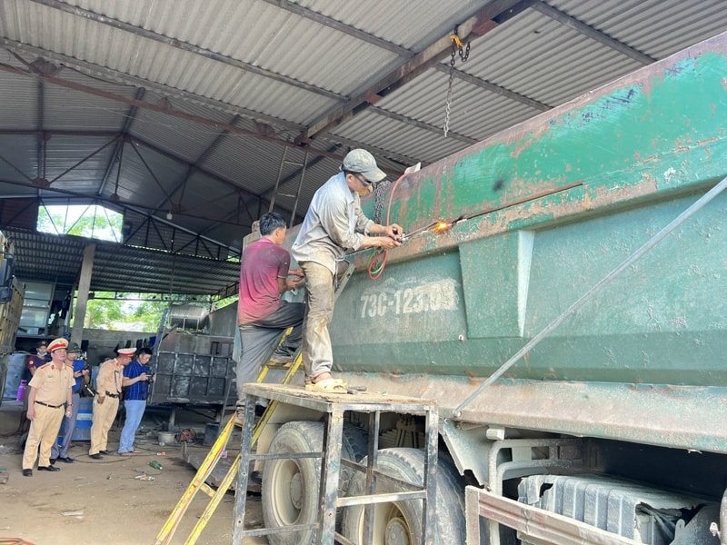Phòng CSGT Quảng Bình giám sát việc cắt bỏ phần thành thùng xe có vi phạm.