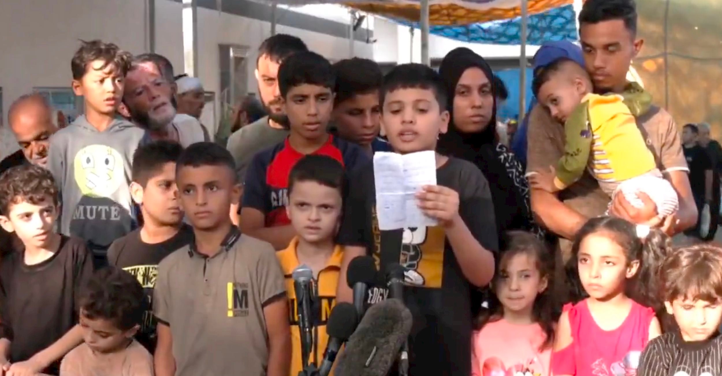 Trẻ em Palestine ở Gaza tổ chức một cuộc họp báo bên ngoài Bệnh viện Al Shifa, kêu gọi sự ủng hộ của thế giới. Ảnh chụp màn hình.