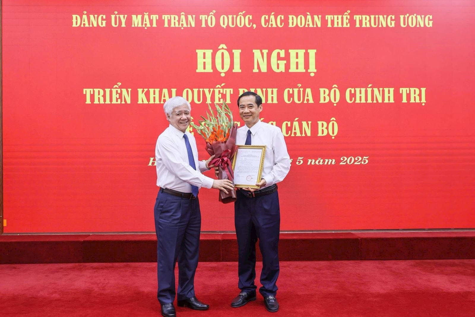 Chủ tịch Đỗ Văn Chiến trao quyết định và tặng hoa chúc mừng ông Nguyễn Thái Học. Ảnh: Quang Vinh