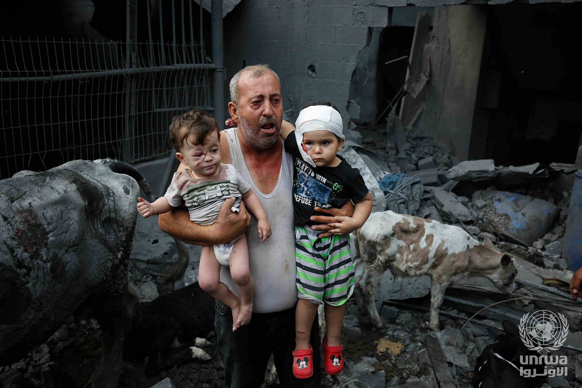 Một người tị nạn Palestine bế những đứa cháu bị thương khỏi vụ đánh bom của Israel vào Trại Nuseirat, Dải Gaza. Ảnh: UNRWA