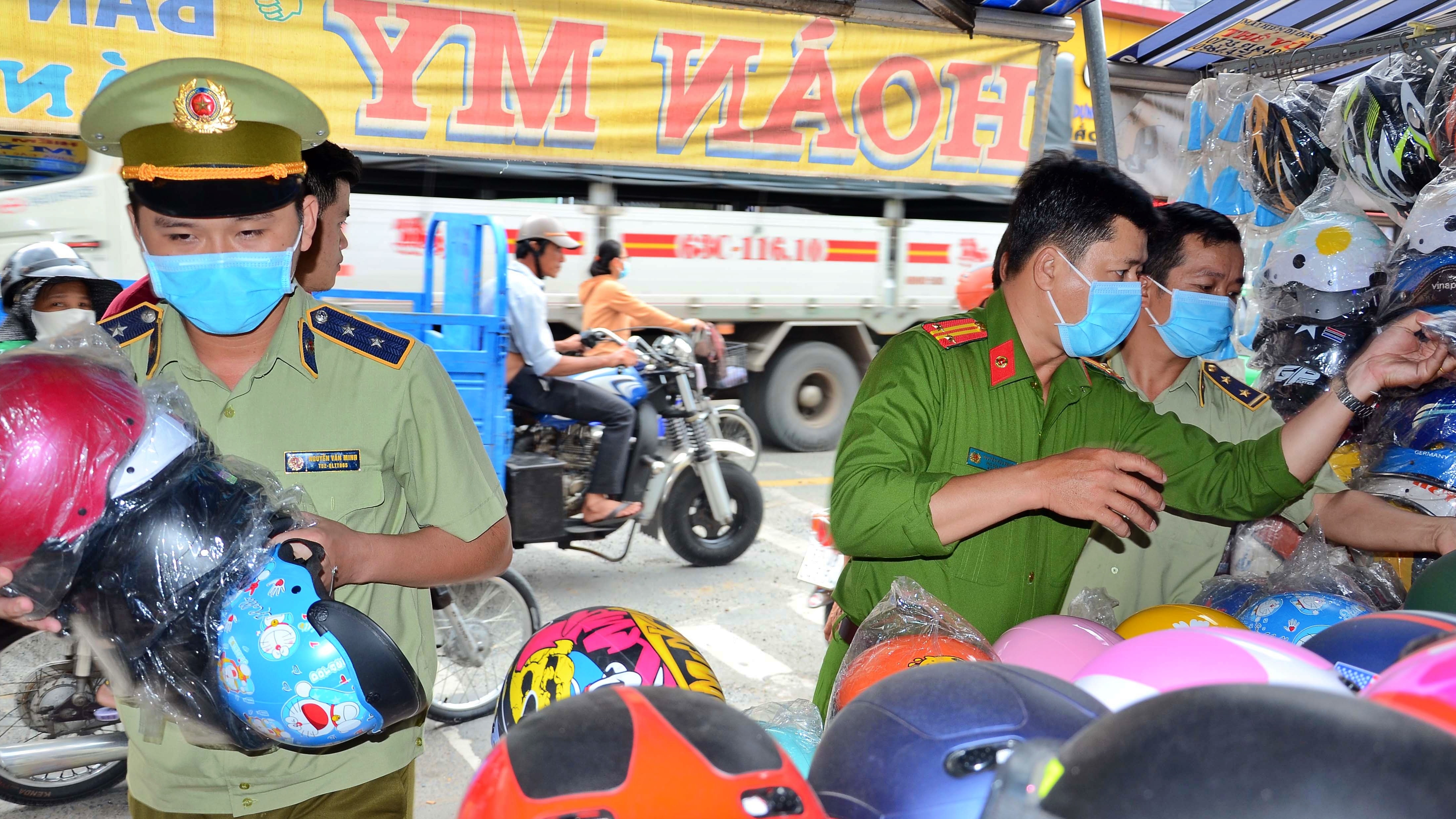 Lực lượng chức năng kiểm tra và thu giữ mũ bảo hiểm giả - Ảnh: Ấp Bắc.