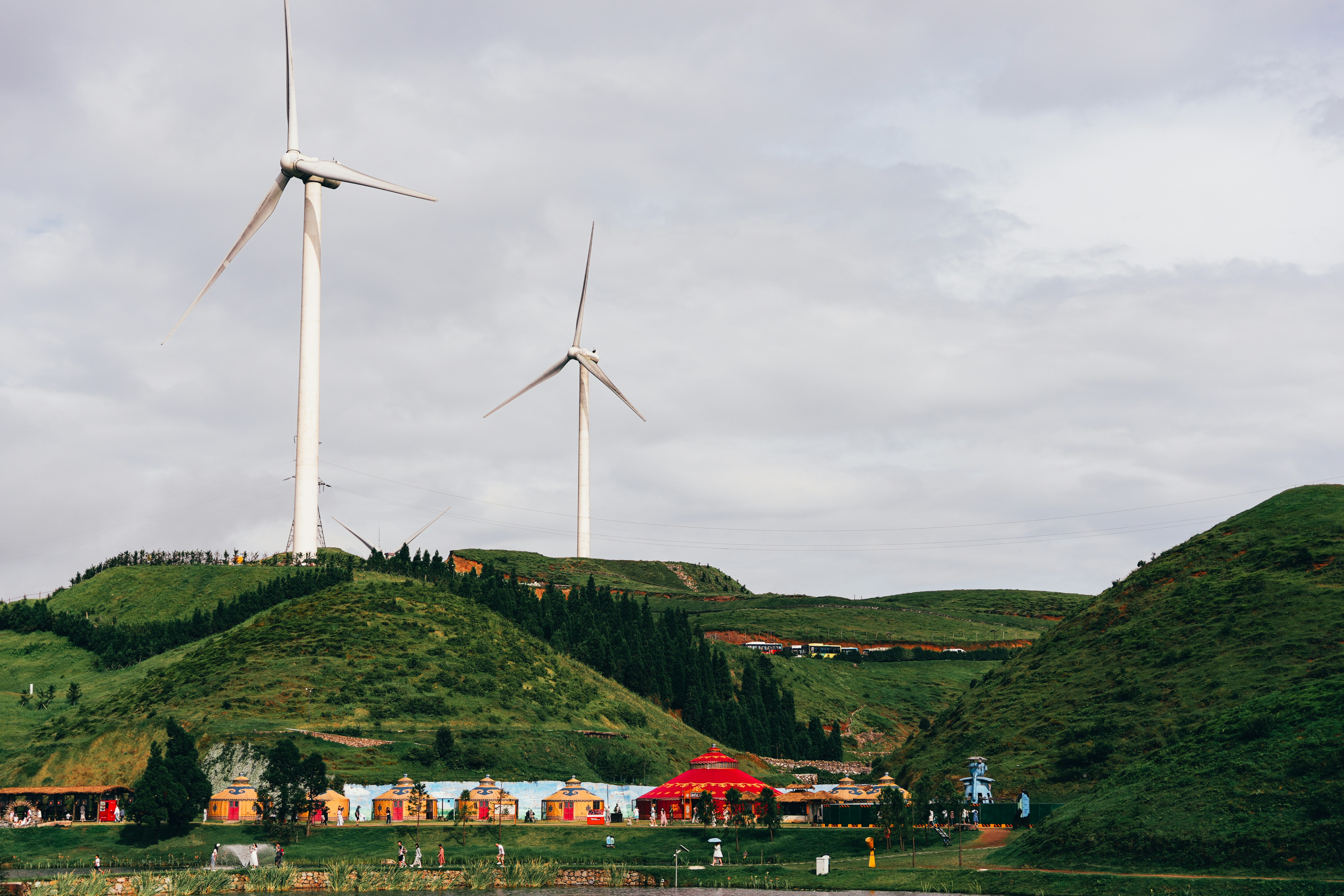 A group of windmills on a hill near a body of water