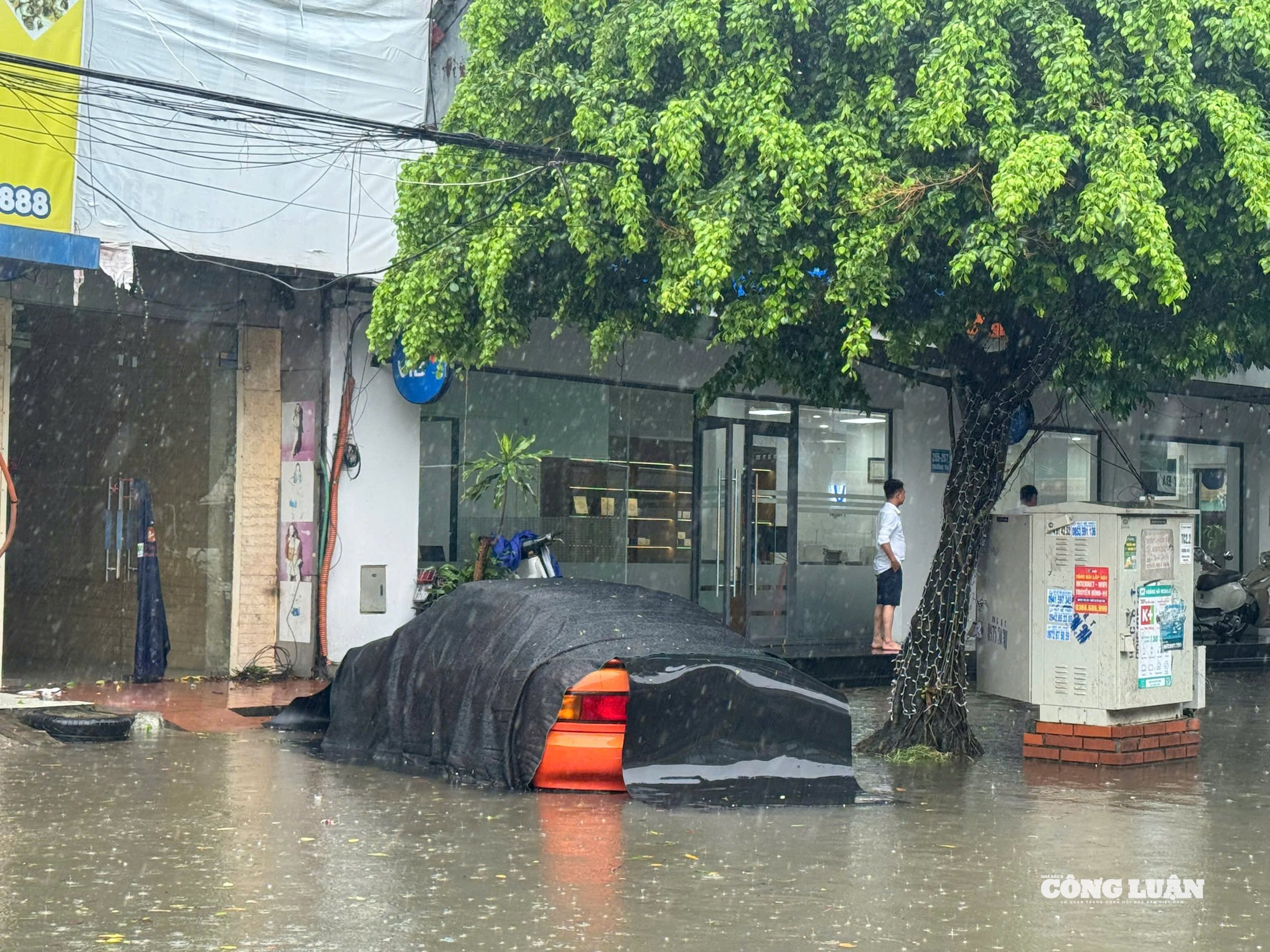 Dù được che chắn rất kỹ nhưng do lượng mưa lớn, nước dâng nhanh khiến chiếc xe ô tô bị ngập trong nước.
