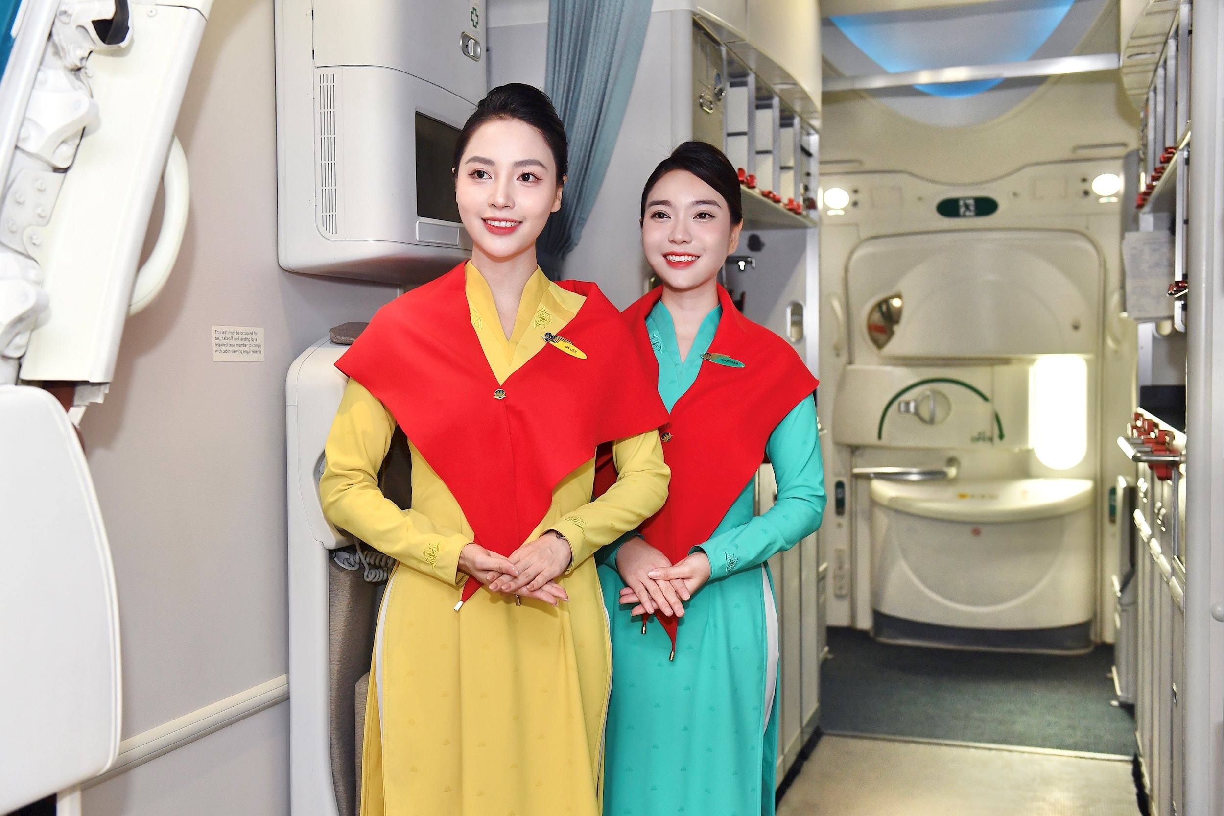 2. Tiếp viên Vietnam Airlines quàng khăn đỏ sao vàng, nở nụ cười chào đón hành khách trong không khí lễ hội