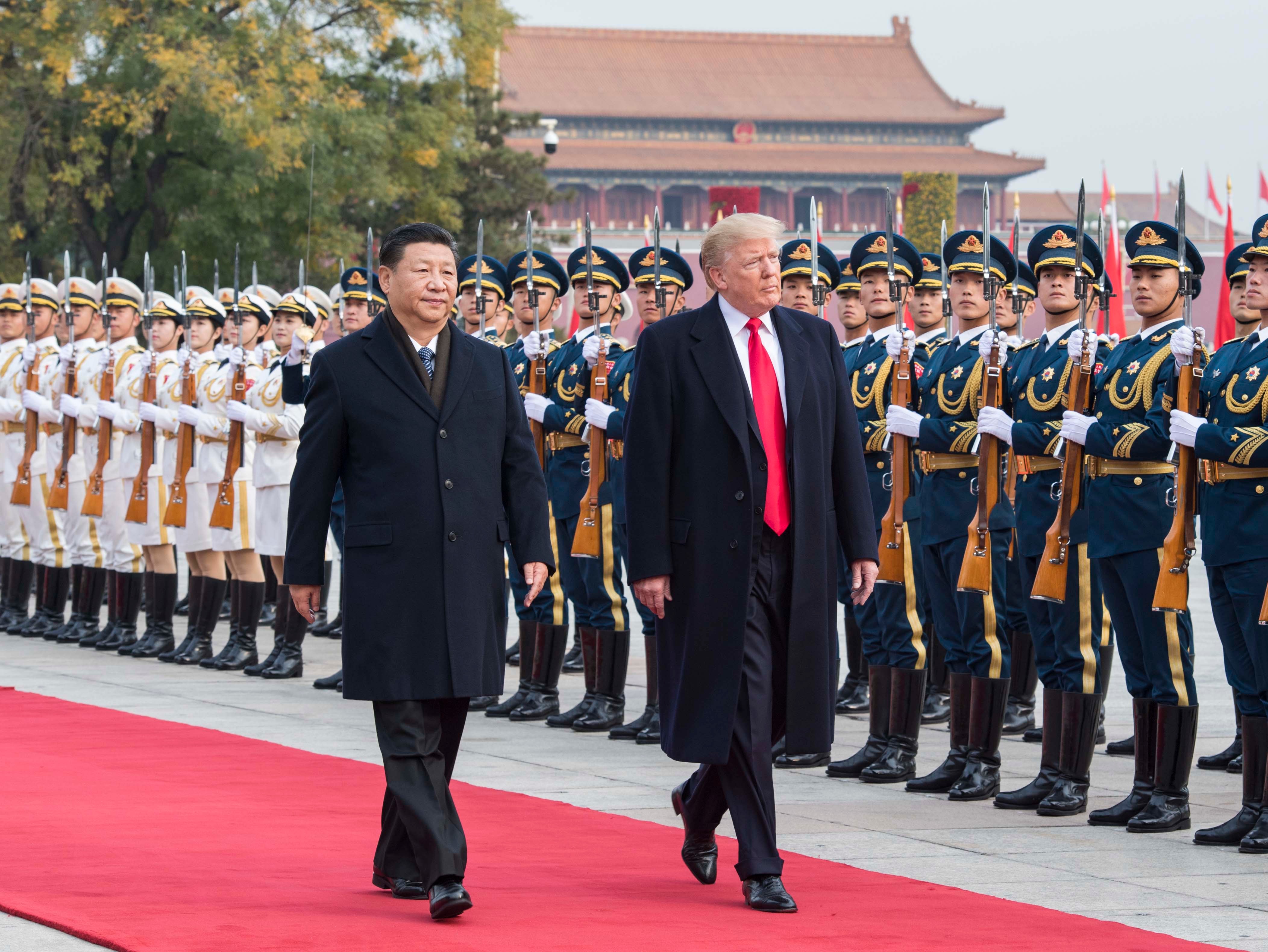 Tập Cận Bình và Donald Trump bước đi trên thảm đỏ cùng đội danh dự quân đội.