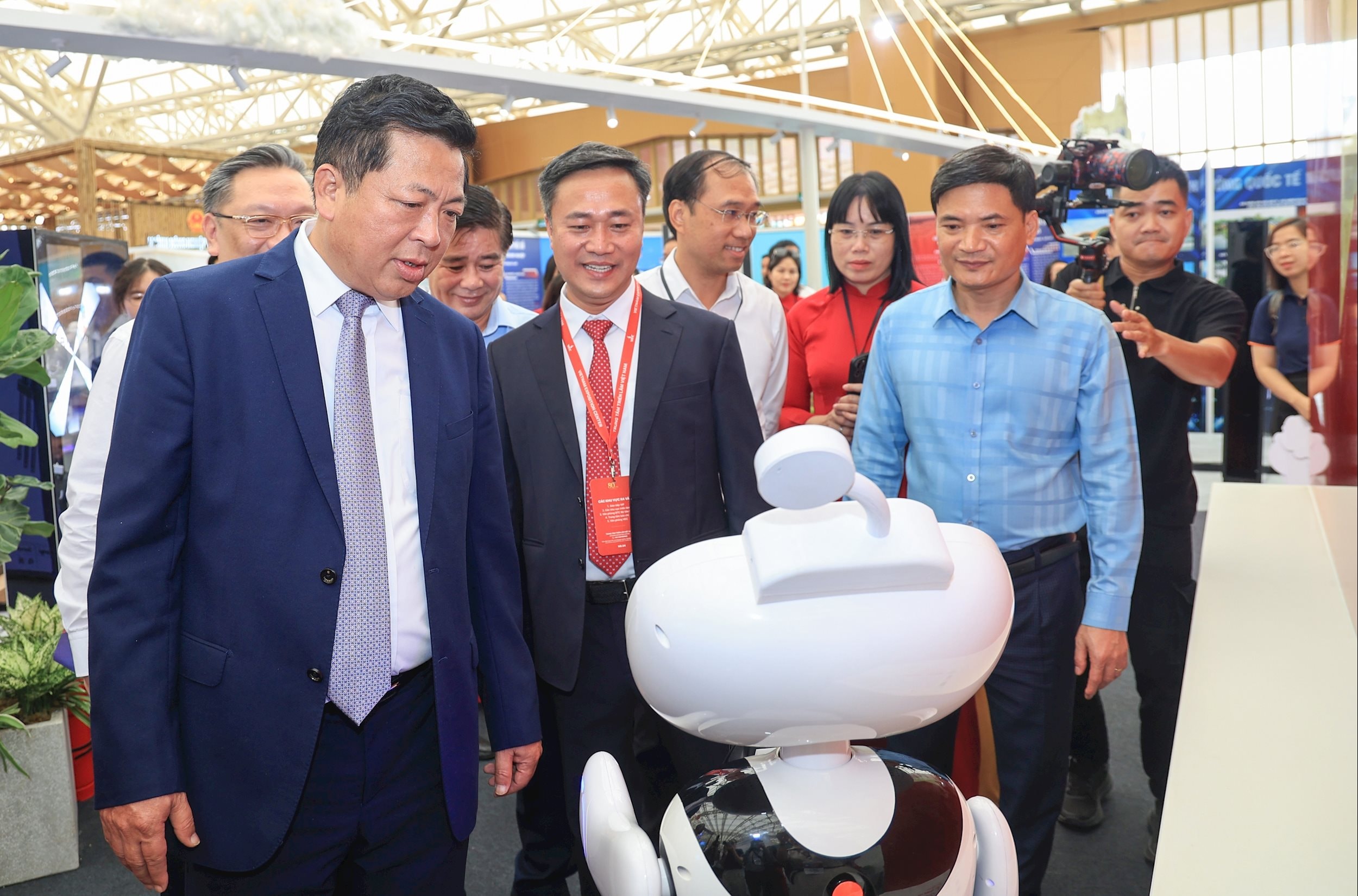 Bộ trưởng Trần Hồng Minh và Thứ trưởng Nguyễn Việt Hùng nghe giới thiệu về robot lễ tân E1 với khả năng cung cấp thông tin nhanh chóng - chi tiết - chính xác tại gian trưng bày của Bộ Xây dựng.