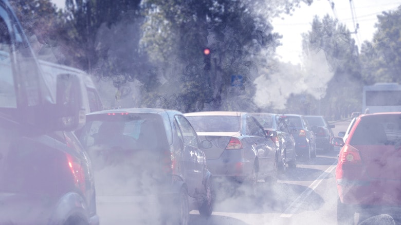 Lines of traffic surrounded by exhaust smoke and haze