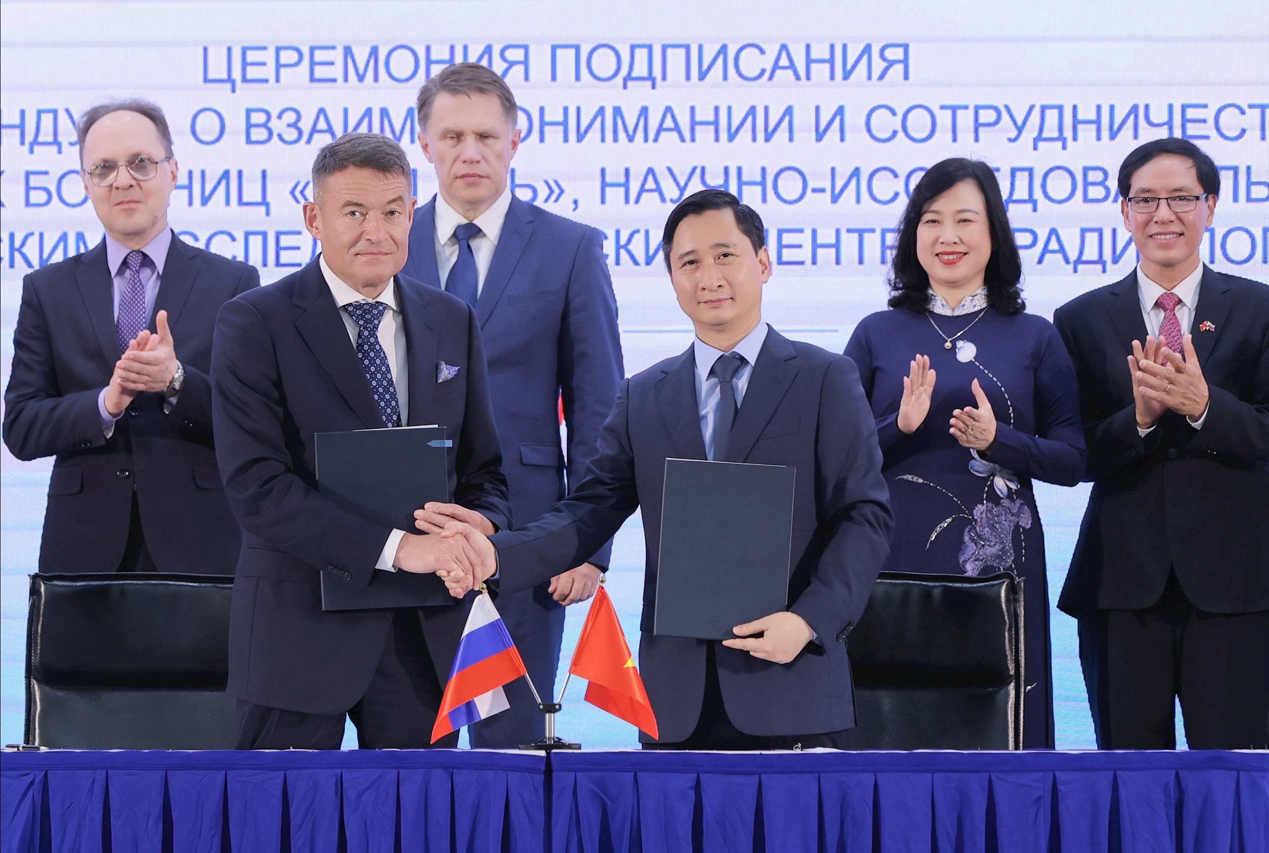 Ông Andrey Kaprin - Tổng giám đốc Trung tâm Y học Quốc gia về Xạ trị - Viện Hertsen Liên bang Nga trao đổi văn kiện hợp tác với ông Ngô Chí Dũng, Chủ tịch HĐQT Hệ thống B…