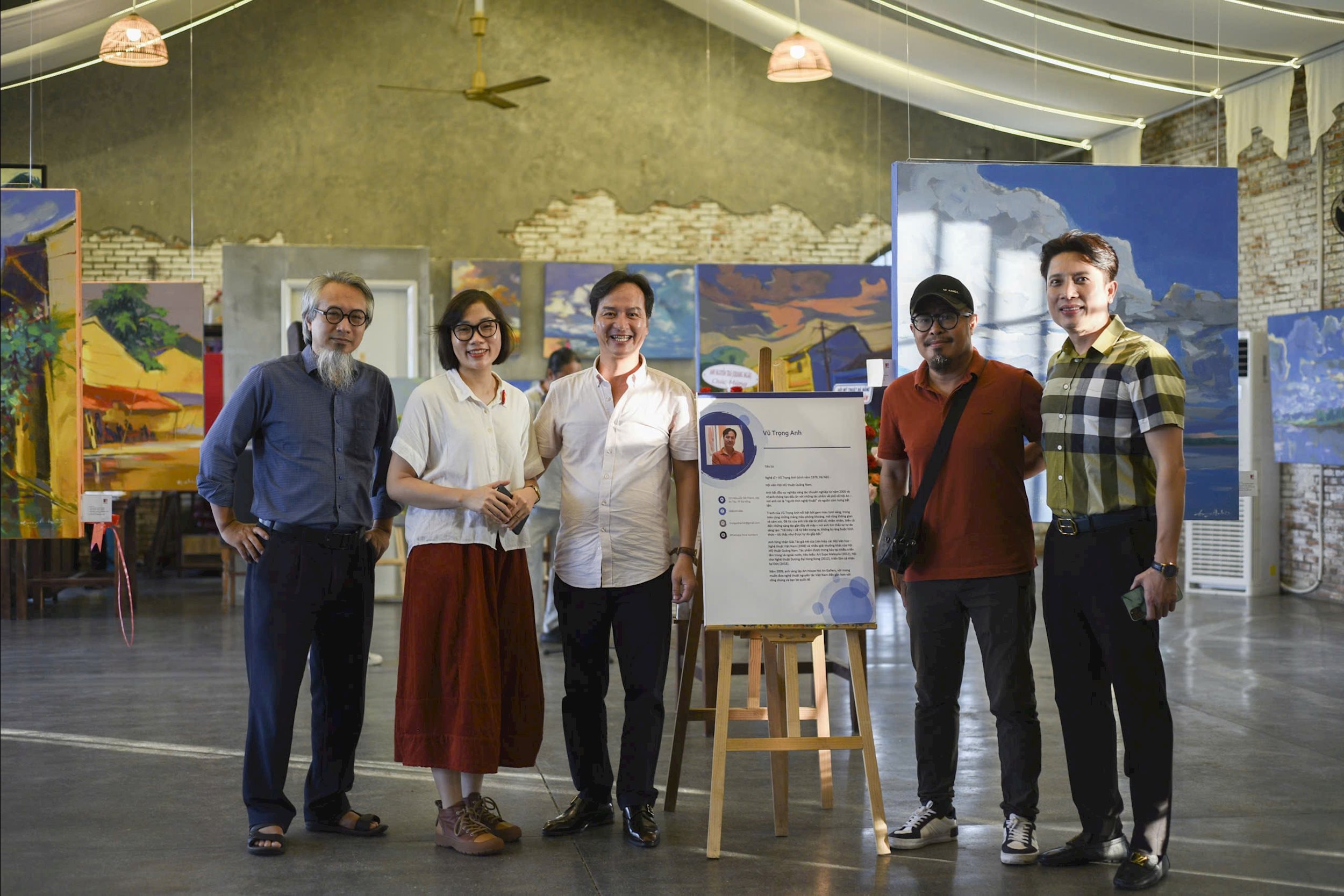 Hoạ sĩ Vũ Trọng Anh (thứ 3 từ trái qua) chụp hình với khách mời tại triển lãm 