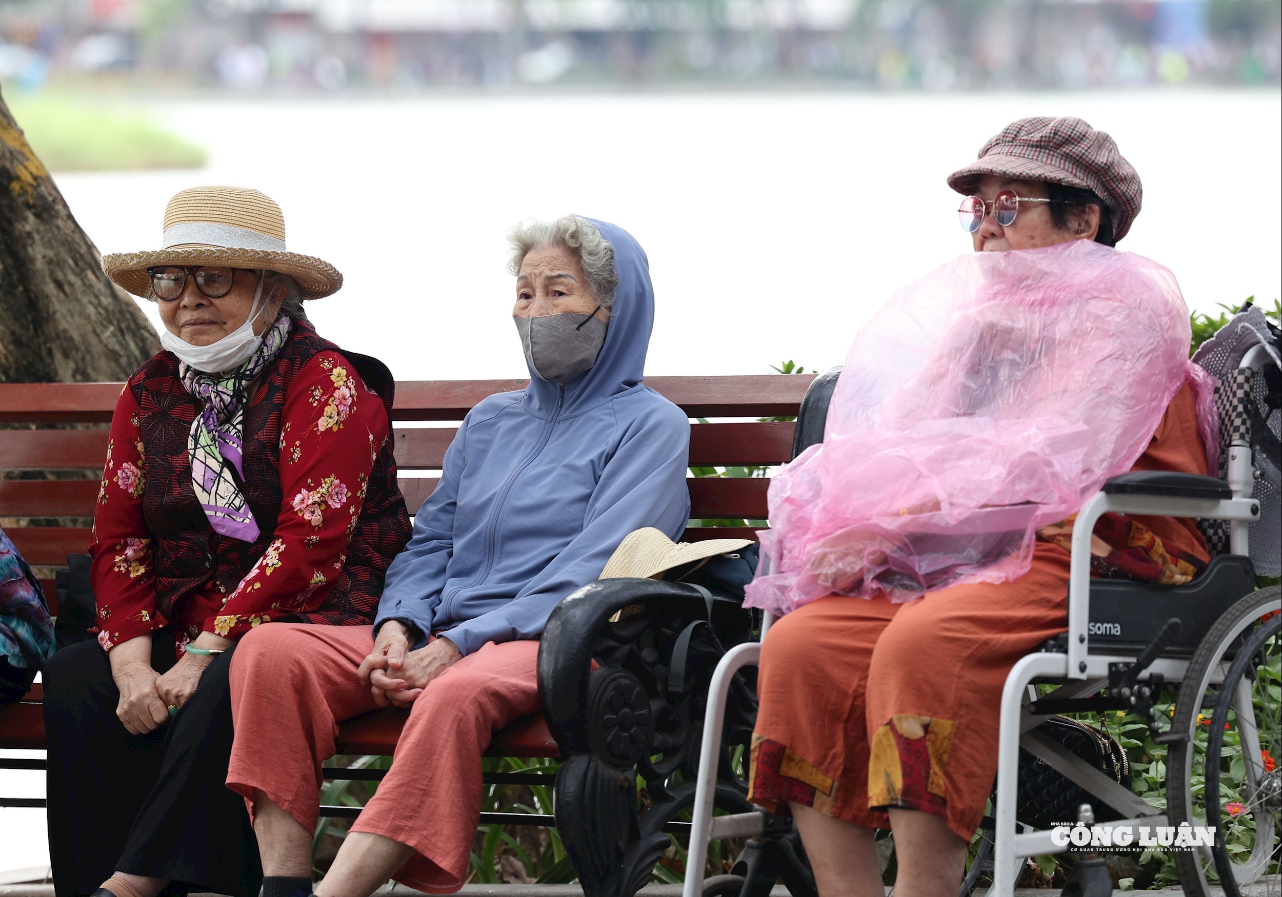 Ngoài áo ấm, nhiều người còn khoác thêm áo mưa để giảm gió lạnh.