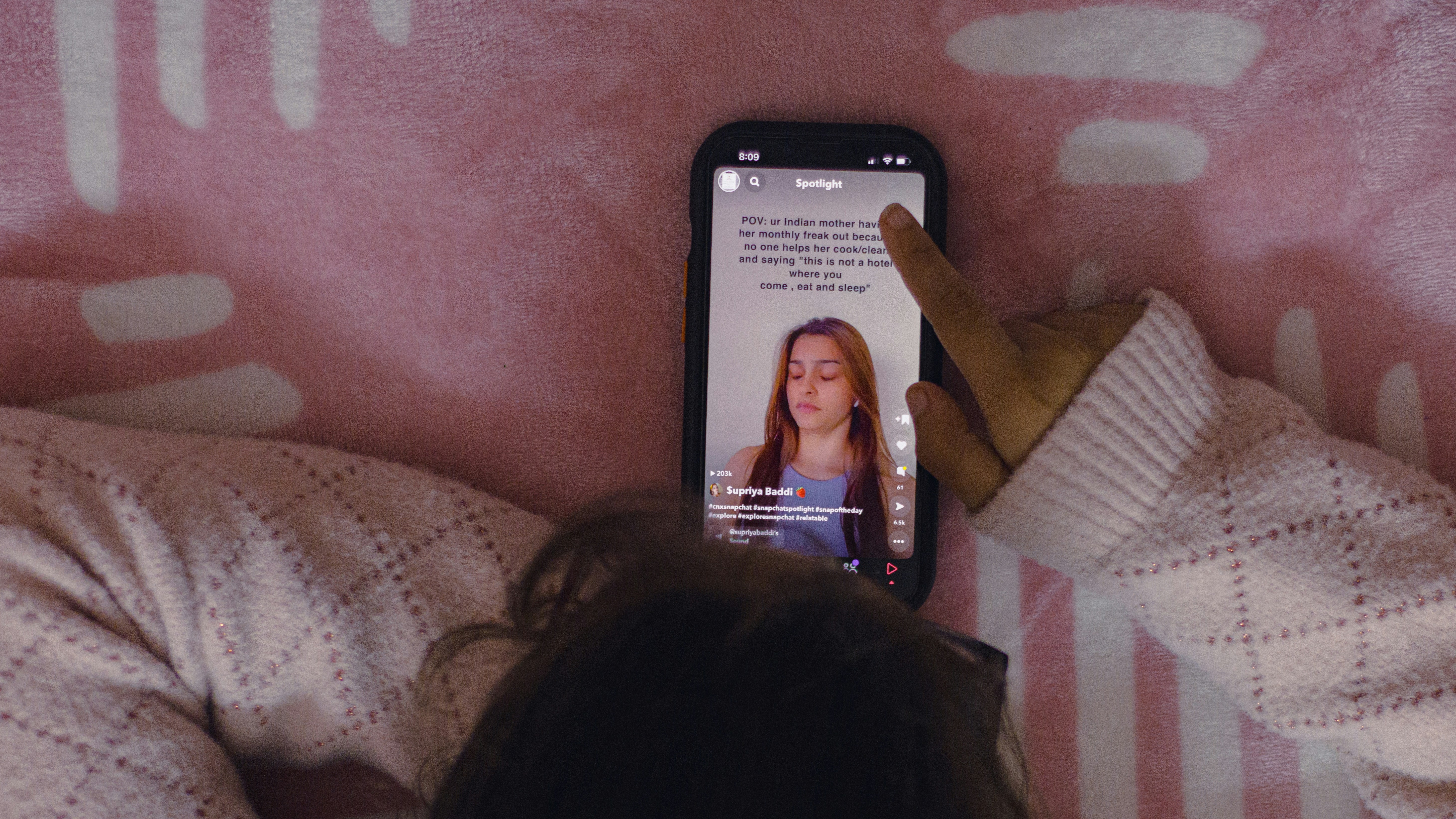 एक व्यक्ति मोबाइल फोन के साथ बिस्तर पर लेटा हुआ है